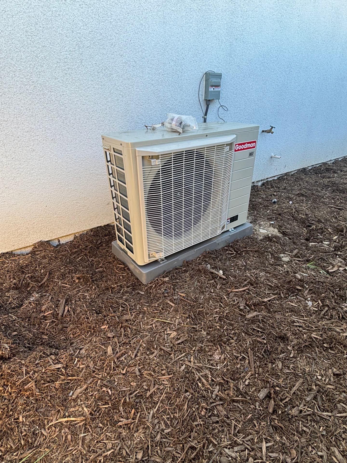 New Goodman R32 condensing unit installed on a side yard pad